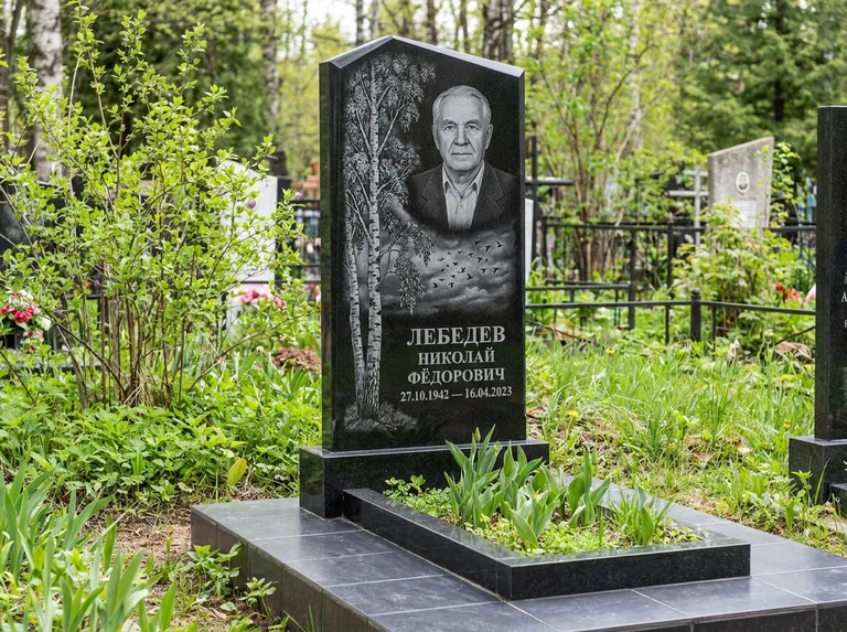 Памятник с гравировкой берёзы: вертикальная стела со скошенным верхом — берёза и стая птиц в небе, гранитный цоколь с тёмной плиткой, работа «Лебедев» в Ярославле