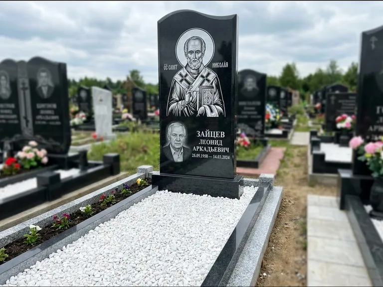 Памятник с гравировкой иконы: стела с крестообразным навершием — икона в резной рамке-киоте, газон без ограды, стриженая трава, работа «Раевская» в Ярославле