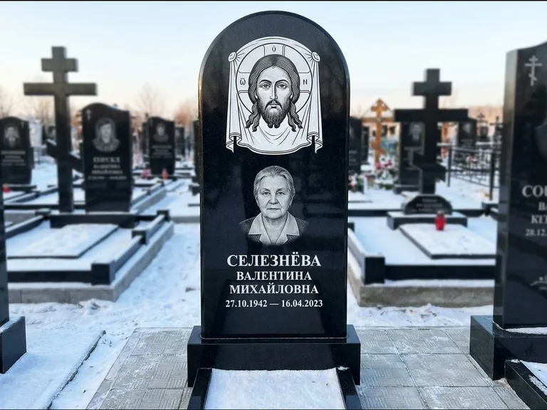 Памятник с гравировкой иконы: небольшая скромная одиночная стела с именной иконой — золочёный нимб на образе, аккуратный участок с газоном, работа «Ковалёв» в Ярославле
