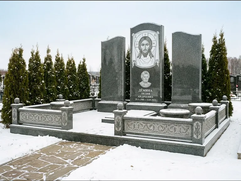 Памятник с гравировкой иконы: узкая вертикальная стела-пилон с ликом — икона в резной рамке-киоте, открытая лужайка без ограды, работа «Одинцов» в Ярославле