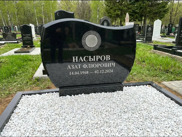 Мусульманский памятник: стела с волнообразным скошенным верхом — гравировка мечети под полумесяцем и звёздами, белая мраморная крошка с бордюром, работа «Насыров» в Ярославле