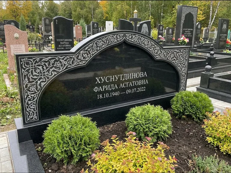 Мусульманский памятник: вытянутая горизонтальная семейная стела с аркой — белая гравировка силуэта мечети с минаретами, участок с декоративными кустами, работа «Зарипова» в Ярославле