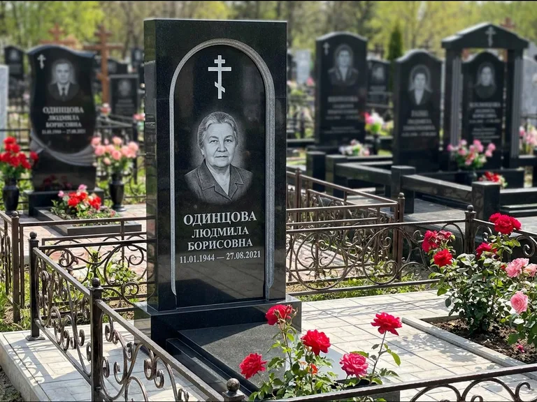 Памятник из чёрного гранита — скромная невысокая стела с крестом с терновым венцом, работа «Лаврентьева» в Ярославле