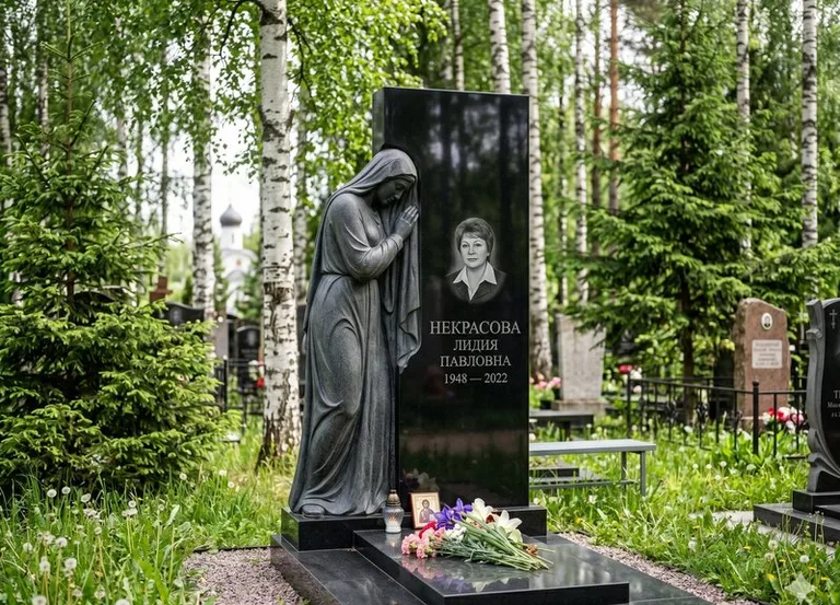 Гранитная фигура скорбящего мужчины у чёрной стелы в Ярославле