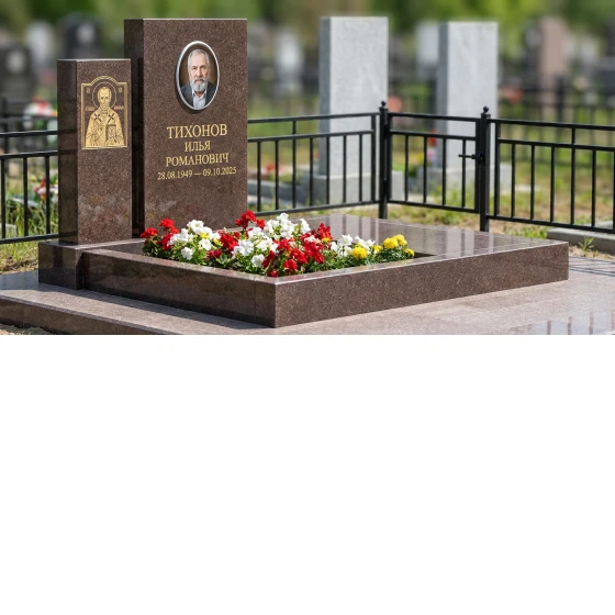 Гранитный памятник строгой формы с оградой