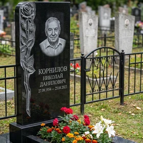Гранитный памятник волнообразный с кованой оградой и золотыми элементами