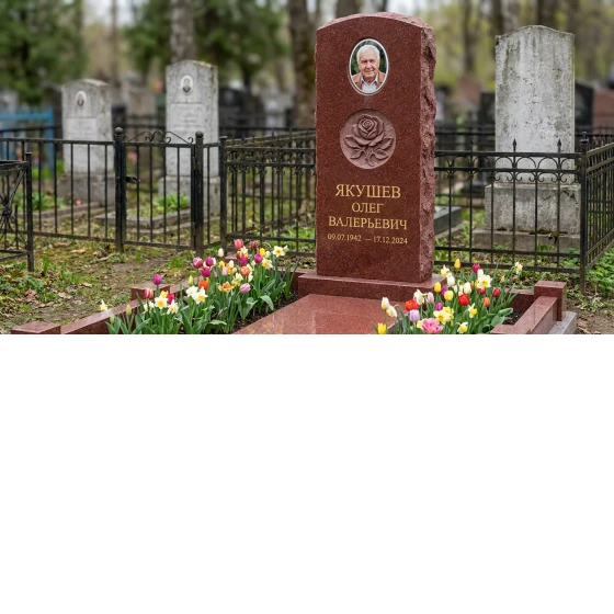 Комбинированный памятник фигурной стелы из красного гранита с цветником