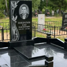 Гранитный памятник с голубями и свечой