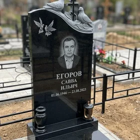 Гранитный памятник с рельефными голубями и православным крестом
