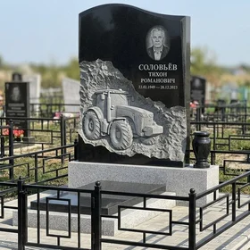 Гранитный памятник с резьбой трактора и портретом